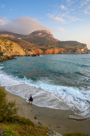Folegandros, Greece - September 24, 2020: A photographer with a tripod taking pictures of the beautiful Agali Beach during the sunset. Folegandros island. Cyclades, Greeceのeditorial素材