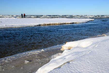 Debki, Poland - February 13, 2021: The Piasnica River during the winter. Two photographers with tripod in background. Baltic Sea, Debki, Polandのeditorial素材