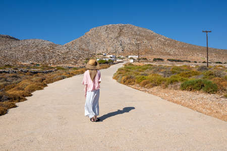 Folegandros, Greece - September 25, 2020: A tourist woman standing on the road in the southern coast of the island of Folegandros. Cyclades, Greeceのeditorial素材