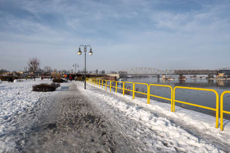 Tczew, Poland - February 21, 2021: Vistula riverbank promenade in Tczew. The historic bridge in background. Poland.のeditorial素材