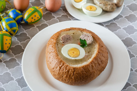 The sour soup (zurek) made of rye flour with sausage and egg served in bread bowl. Popular Easter...