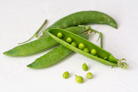 Fresh green peas on a white background