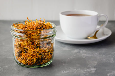 Herbal tea with dried marigold flowers. Calendula tea in a white cup.の写真素材