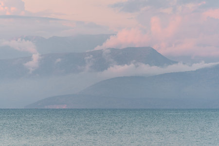 Albania coast surrounded by clouds during sunset seen from Corfu island in Greece
