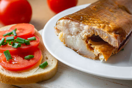 Smoked whitefish on a plate with tomato sandwichの写真素材