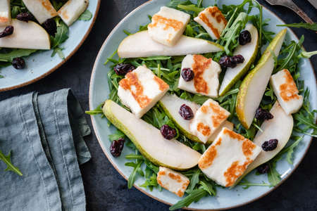 Salad with Halloumi cheese, pear, arugula, and cranberryの写真素材