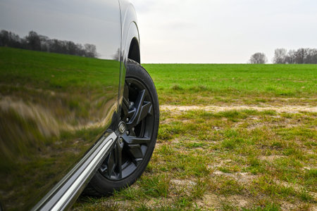Puck, Poland - April 16, 2023: Close up the front wheel of a car on a country road. Rear side view...