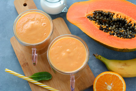 Fresh papaya, banana, orange fruit smoothie with coconut milkの写真素材