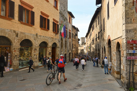 San Gimignano, Italy - April 30, 2023: Tourists visiting the Old Town of San Gimignano. The town is famous for its medieval architecture.のeditorial素材