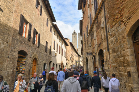 San Gimignano, Italy - April 30, 2023: Tourists visiting the ancient streets of San Gimignano. The town is famous for its medieval architecture.のeditorial素材