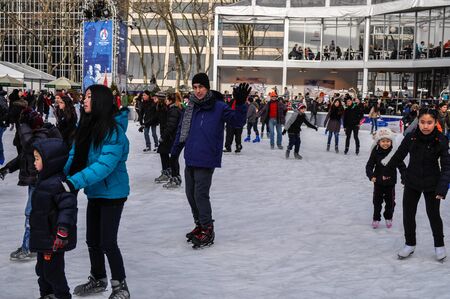 New York City, NY / USA - 12 23 2013: People are enjoying ice skating at Bryant park Midtown Manhattan in front of the New York Public library with a Christmas tree during Christmas holiday season.のeditorial素材