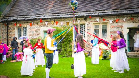 Milton Abbas / UK - July 29 2017: Children are dancing traditional dance during the 18th century street in Milton Abbas village, Dorset, UK. Traditional English medieval street fair in the countrysideのeditorial素材
