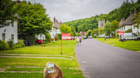 Milton Abbas, Dorset / UK - 07 11 2017: Old Medieval English village in the southwest of the UK. Street with old thatched houses in England. Retro vintage photography.のeditorial素材