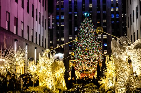 New York City, NY / USA - 12 23 2013: angels with big christmas tree with light in front of the Rockefeller center. Christmas famous decorations in Midtown, Manhattan in the New York City downtown.のeditorial素材