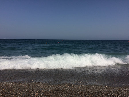 Sea waves on a pebble beach in the Mediterranean Sea.の写真素材
