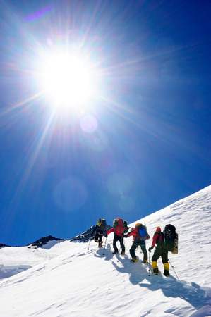 Group of mountain backpackers walking on snowの写真素材