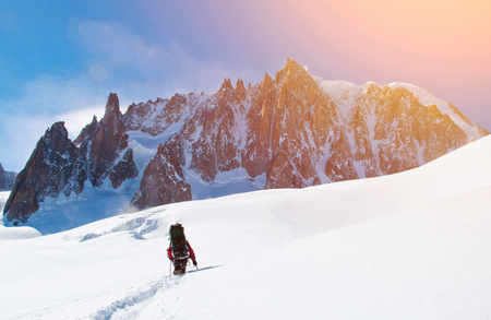 Hiker reaches the summit of mountain peak. Success, freedom and happiness, achievement in mountains. Active sport concept.の写真素材