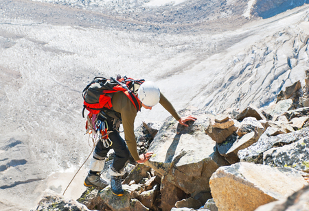 Climber  reaches the summit of mountain peak. Success, freedom and happiness, achievement in mountains. Climbing sport concept.の写真素材
