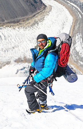 Hiker reaches the summit of mountain peak. Success, freedom and happiness, achievement in mountains. Active sport concept.の写真素材