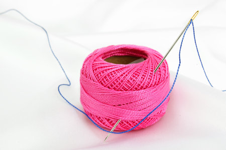 Colored thread, needles and buttons on a white background 