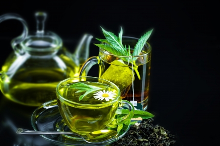 Cup with green tea and green leaves の写真素材