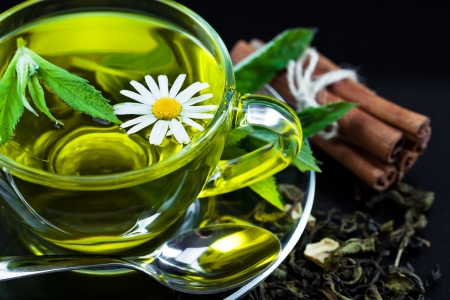 Cup with green tea and green leaves の写真素材