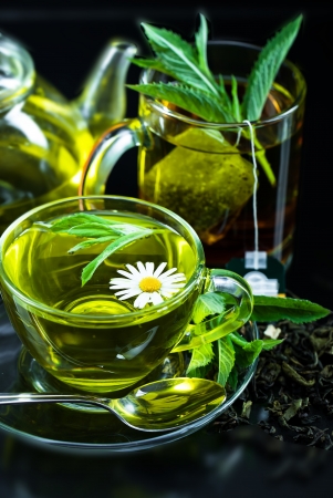 Cup with green tea and green leaves の写真素材