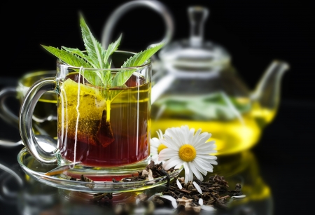 Cup with green tea and green leaves の写真素材