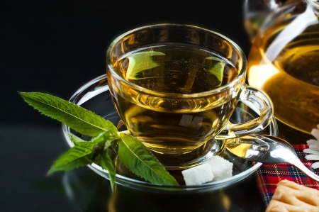 Cup with green tea and green leaves の写真素材