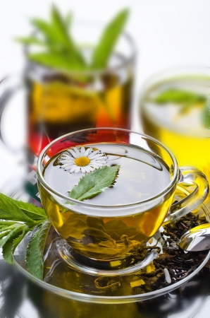 Cup with green tea and green leaves の写真素材