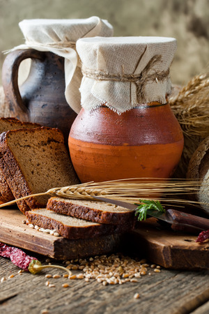 fresh bread and rolls with ears of wheat on the tablefの写真素材