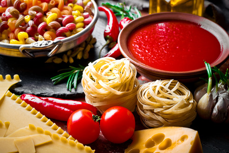 Raw pasta on the table in the composition with accessories for the kitchenの写真素材