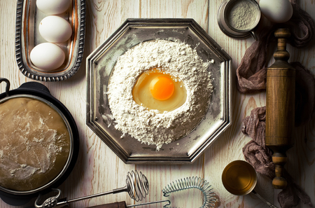 Dough with flour on an old background in a composition with kitchen accessoriesの写真素材