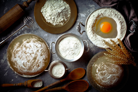 Dough with flour on an old background in a composition with kitchen accessoriesの写真素材