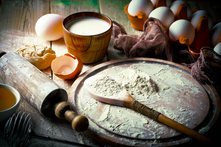 Dough with flour on an old background in a composition with kitchen accessoriesの写真素材