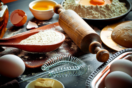 Dough with flour on an old background in a composition with kitchen accessoriesの写真素材