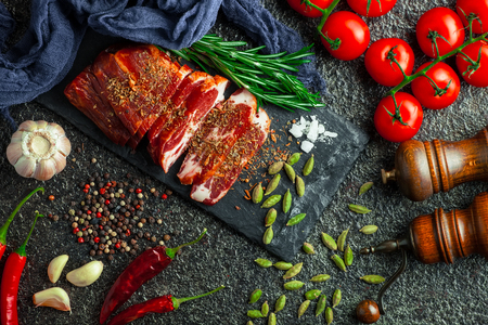 Raw meat on the kitchen table on a metallic background in a composition with cooking accessoriesの写真素材