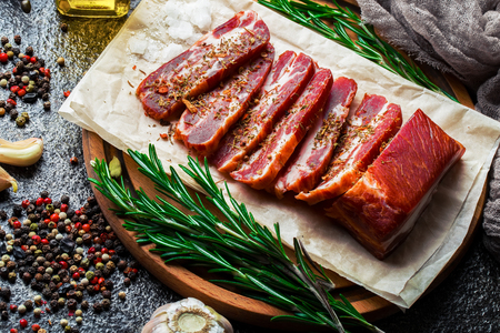 Raw meat on the kitchen table on a metallic background in a composition with cooking accessoriesの写真素材
