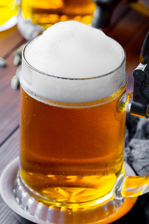 Light foam beer in a glass on an old backgroundの写真素材