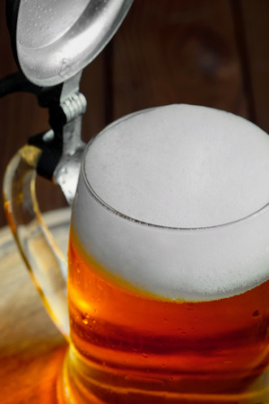 Light foam beer in a glass on an old backgroundの写真素材