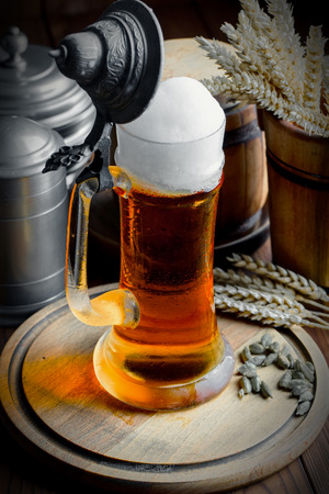 Light foam beer in a glass on an old backgroundの写真素材