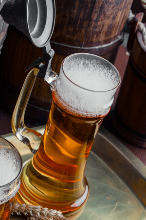 Light foam beer in a glass on an old backgroundの写真素材