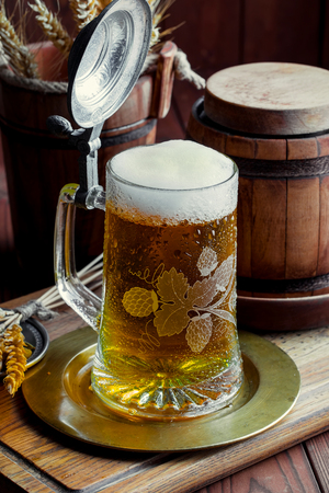 Light foam beer in a glass on an old backgroundの写真素材