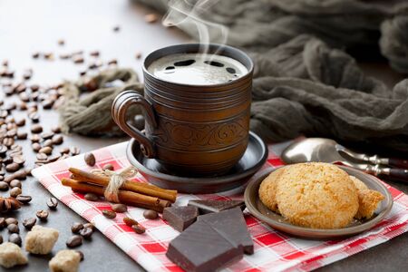 Coffee in a cup and saucer on checkered fabricの写真素材