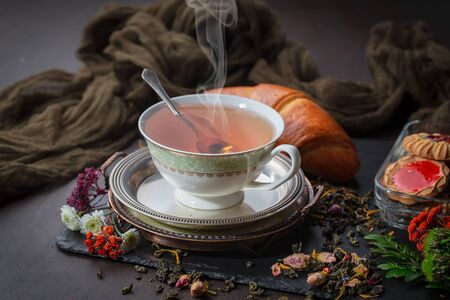 Tea hot drink on old background in composition on the tableの写真素材