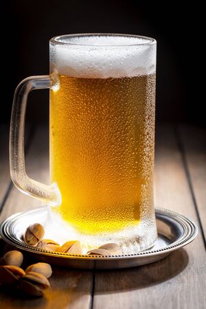 Light beer in a glass on a table in composition with accessories on an old backgroundの写真素材