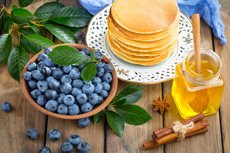 Pancakes with fresh blueberries and honey on a wooden backgroundの写真素材