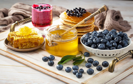 Blueberry jam with fresh berries and honeycombs on wooden backgroundの写真素材