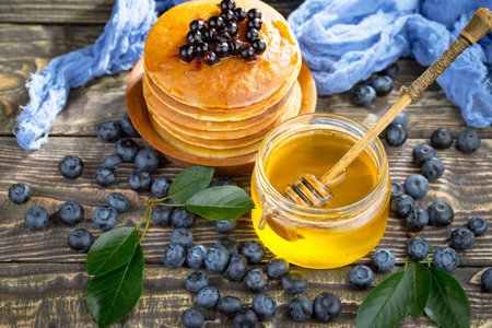 Pancakes with blueberries and honey on a wooden background.の写真素材