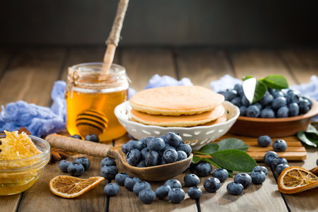 Pancakes with blueberries and honey on a wooden background.の写真素材